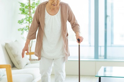 杖をついて歩くシニア女性